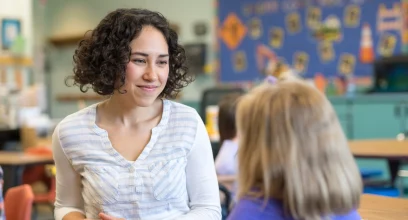 Salle de classe de primaire, une enseignante face à une élève vue de dos